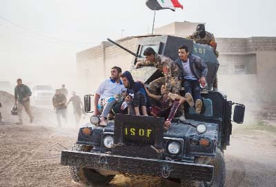 Iraqi soldiers and family rush 12-year-old Mohammed (C-R) and 15-year-old Shafiq (C-L) to an outdoor field clinic on their Humvee in the Al-Samah neighbourhood in Mosul on Sunday.