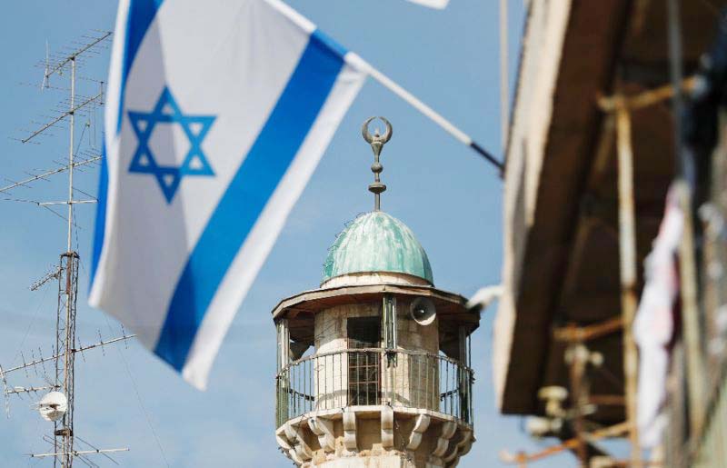 An Israeli flag is pictured in front of the minaret of a mosque in the Arab quarter of Jerusalem's Old City on Monday Israeli Prime Minister Benjamin Netanyahu said he backed a bill limiting the volume of calls to prayer from mosques, a proposal governme
