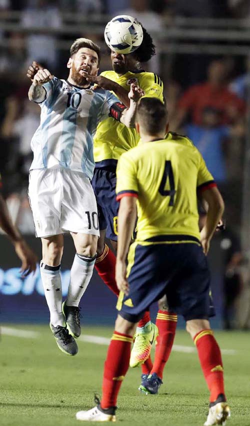 Argentina's Lionel Messi jumps for a ball against Colombia's Carlos Sanchez during a 2018 World Cup qualifying soccer match in San Juan, Argentina on Tuesday.