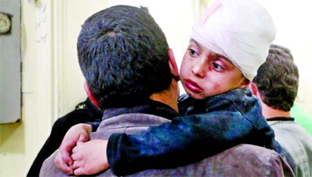 While hundred flee a boy receives medical treatment after being injured in an airstrike on Wednesday in Aleppo.