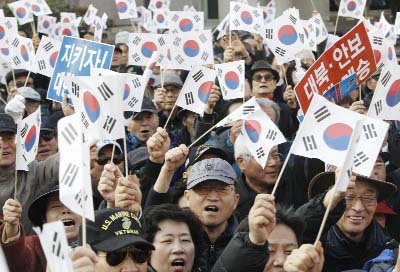 Protesters supporting South Korean President Park Geun-hye wave national flags during a rally opposing her resignation in Seoul, South Korea on Thursday.