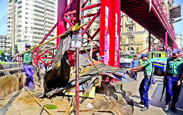 Police removing illegal structures adjacent to the foot-over bridge in a bid to make pedestrians movement easy. (Inset) Two pedestrians fined for violating rules while crossing street instead of using footover bridge on Thursday.