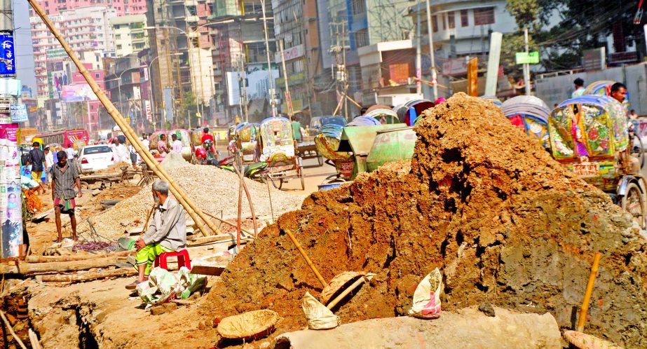 WHO CARES! Unplanned development work accompanied by contractor's lack of civic sense often creates intolerable situation. This photo was taken on Saturday shows that labourers are busy to clean a drain while a huge quantity of sand and other materials