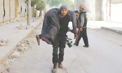 A member of the White Helmets rescue group carries an injured man.