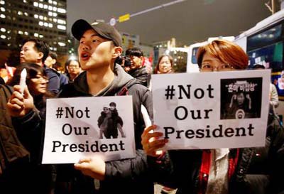 Protesters shout slogans after they are blocked by riot policemen in a road nearby the presidential Blue House during their march calling South Korean President Park Geun-hye to step down in Seoul, South Korea