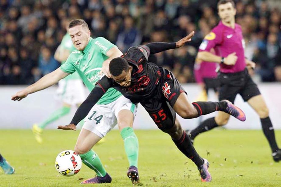 Nice's Wylan Cyprien (right) falls as he challenges for the ball with Saint-Etienne's Jordan Veretout, during their French League One soccer match in Saint-Etienne, central France on Sunday.