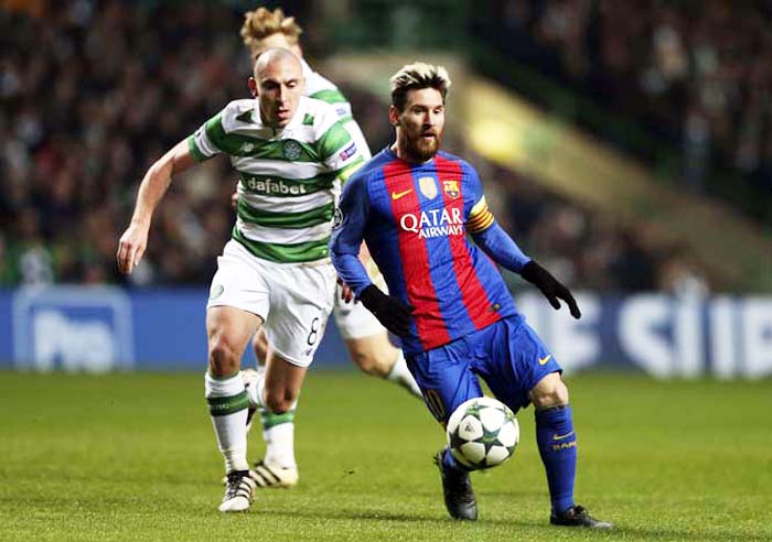 Celtic's Scott Brown (left) and Barcelona's Lionel Messi challenge for the ball during the Champions League Group C soccer match between Celtic and Barcelona at Celtic Park stadium in Glasgow, Scotland on Wednesday.