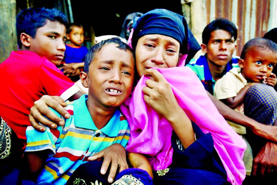 A Rohingya Muslim woman and her son cry after being caught by Border Guard Bangladesh while illegally crossing at a border check point in Cox's Bazar, Bangladesh.