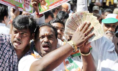 Members of the Congress Party hold up the banned 500 and 1000 rupee notes as they shout slogans during a protest as part of 'Jan Aakrosh Diwas' in front of the Reserve Bank of India.
