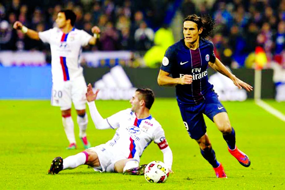 Paris Saint Germain's Edinson Roberto Cavani (right) controls the ball after a challenge with Lyon' players during their French League One soccer match, in Decines, near Lyon, central France on Sunday.