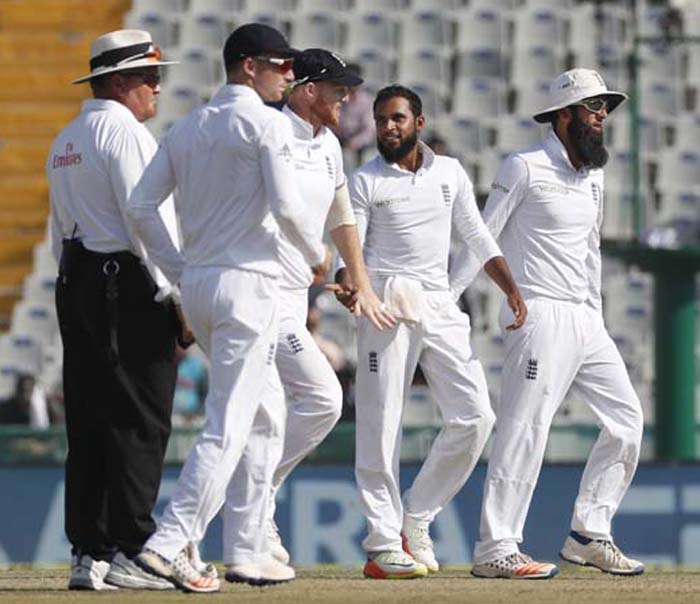 England's cricketers congratulate their teammate Adil Rashid (second from right) after taking the wicket of India's Ravindra Jadeja on the third day of their third cricket test match in Mohali, India on Monday.