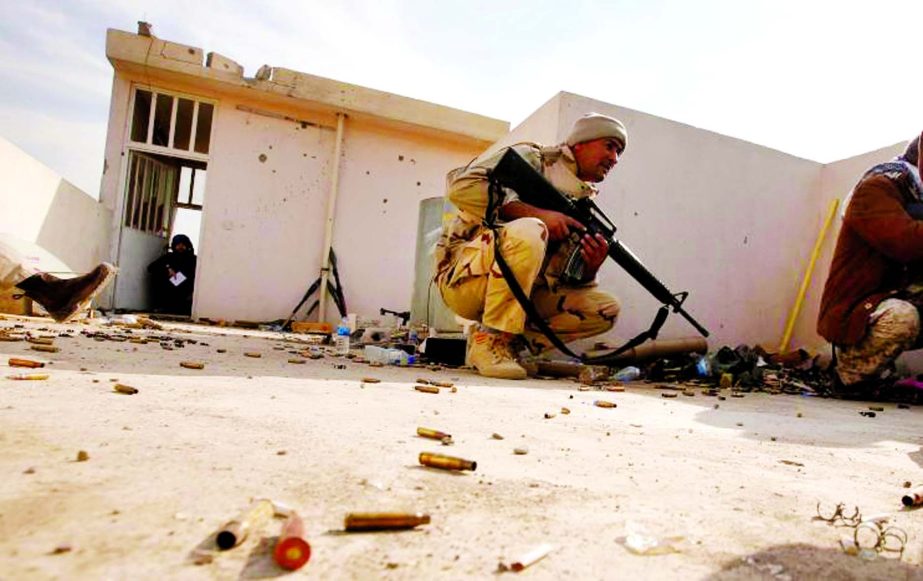 Iraqi soldiers take cover during operation against Islamic State militants in the frontline neighbourhood of Intisar, eastern Mosul.