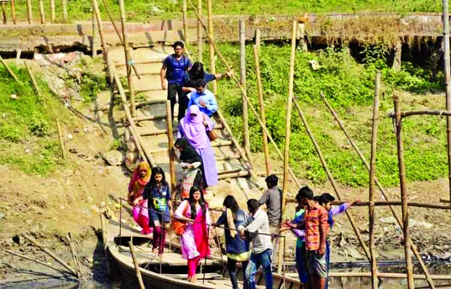 Though unbelievable, the residents of eastern Banasree have to cross a canal walking through the boats and climbing up a bamboo bridge. Inhabitants demanding for setting up a bridge. This photo was taken on Monday.