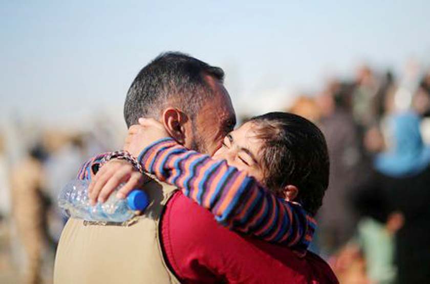 A displaced Iraqi father, who fled the Islamic State stronghold of Mosul, is hugged by his displaced daughter as they meet for the first time since they fled Mosul, upon the father's arrival at Khazer camp.