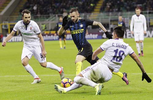 Inter Milan's Marcelo Brozovic (center) dribbles padt Fiorentina's Carlos Salcedo (right) and Fiorentina's Milan Badelj during the Serie A soccer match between Inter Milan and Fiorentina at the San Siro stadium in Milan, Italy on Monday.