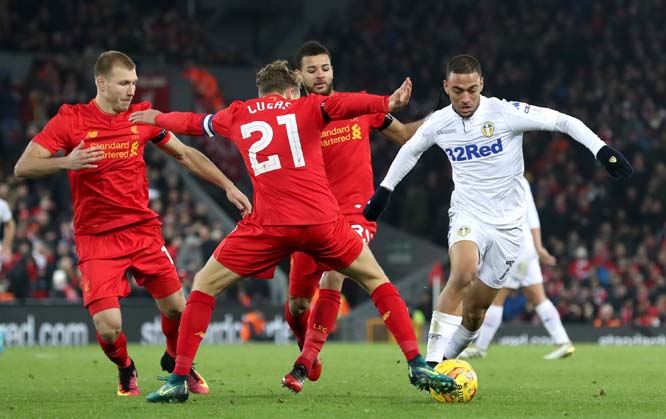 Liverpool's Ragnar Klavan (left) Lucas (center) and Leeds United's Kemar Roofe battle for the ball during their English League Cup quarterfinal soccer match at Anfield, Liverpool, England on Tuesday.