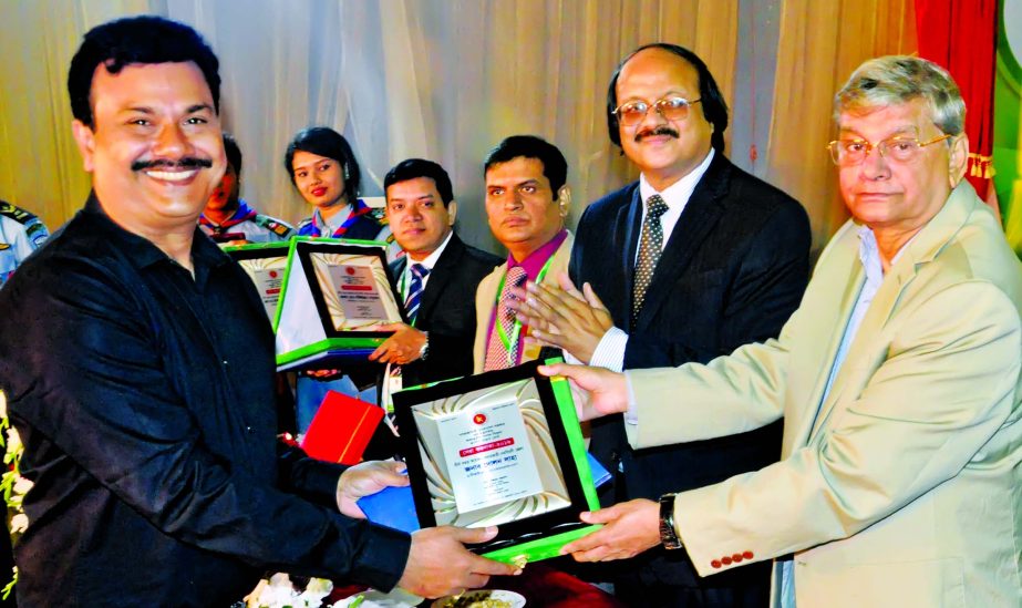 State Minister for Finance and Planning Md Abdul Mannan, handling over the Tax Card and Crest to Babu Dolon Saha, the long time tax-payee of Narshingdi District at NBR Bhaban in the city recently. Md Najibur Rahman, Chairman of NBR was also present among