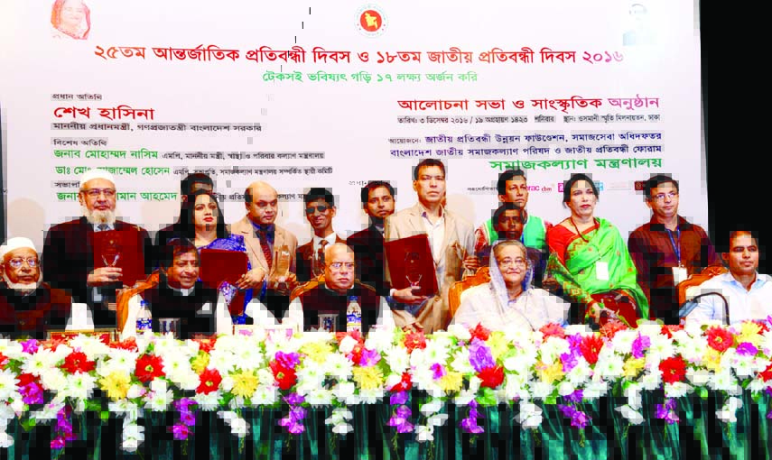 Prime Minister Sheikh Hasina poses for photograph with the recipients of awards at a ceremony organised on the occasion of International Disabled Day at Osmani Memorial Auditorium in the city on Saturday. BSS photo