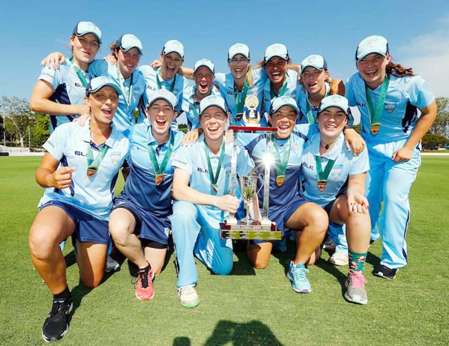 NSW players celebrate with the trophy during the WNCL final match between Queensland and New South Wales at Allan Border Field in Brisbane, Australia on Saturday.