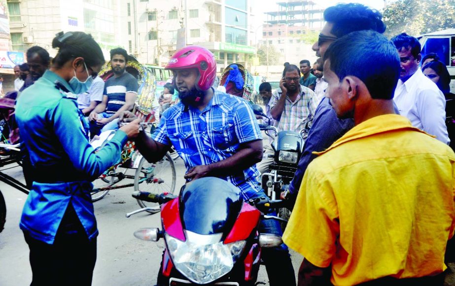 A woman police sergeant examining papers of motor-bikes marking the Traffic Week. This photo was taken from city's Doyaganj area on Saturday.