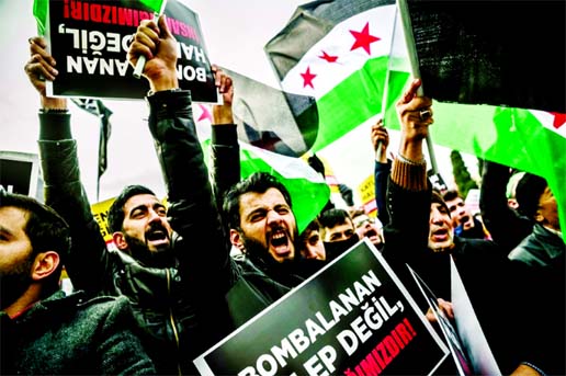 Men hold placards and wave Syrian national flag as they chant slogans in Istanbul during a demonstration to protest against the Syrian official regime and Russia's military operations in Aleppo. Internet photo