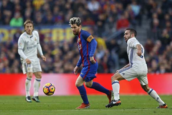 Barcelona's Lionel Messi (center) vies for the ball with Daniel Carvajal (right) during the Spanish La Liga soccer match between FC Barcelona and Real Madrid at the Camp Nou stadium in Barcelona, Spain on Saturday. The match ended in a 1-1 draw.