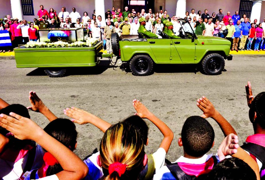 Schoolchildren salute as the urn with the ashes of Cuban leader Fidel Castro enters Santiago, Cuba.