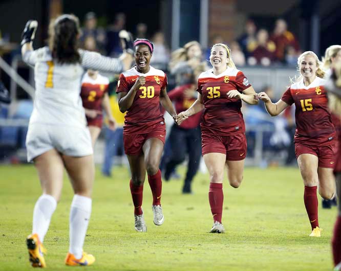 Southern California's Sydney Johnson (30), Leah Pruitt (35) and Jalen Woodward (15) rush out on to the field to celebrate with teammate goalkeeper Sammy Jo Prudhomme (1) after a 3-1 victory against West Virginia during the NCAA Women's College Cup socce