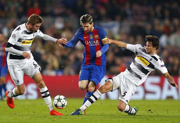 Moenchengladbach's Christoph Kramer (left) and Tobias Strobl (right) challenge for the ball with Barcelona's Lionel Messi (center) during the Champions League, Group C, soccer match between FC Barcelona and Borussia Moenchengladbach at the Camp Nou stad