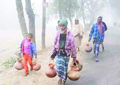 JESSORE: Date juice collectors in Jessore are going to collect juice with earthen pots from trees early in the morning .This picture was taken on Wednesday.