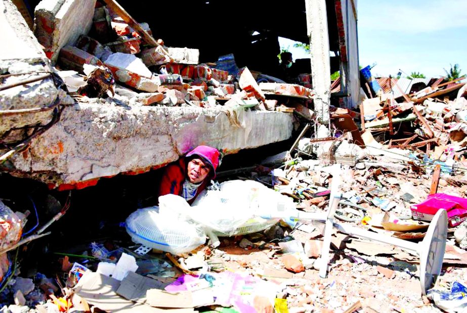 A man retrieve fans from a collapsed shop following a strong earthquake in Meureudu, Pidie Jaya, Aceh province, Indonesia.