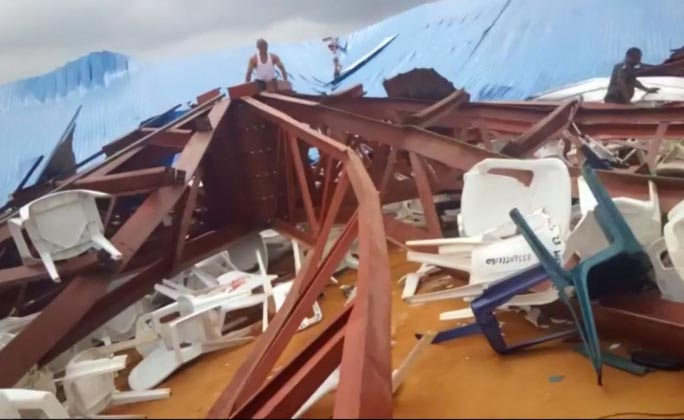 Local people survey the scene after a church roof collapsed in Uyo, Nigeria. Metal girders and the roof of a crowded church collapsed onto worshippers in southern Nigeria.