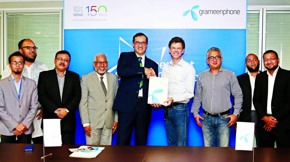 Petter B Furberg, CEO of Grameenphone (GP) and Stephane Norde, Managing Director of Nestle Bangladesh Ltd exchanging documents after signed an agreement in the city on Sunday. Under the deal, GP's Star Customers will enjoy 15 percent discount for buying