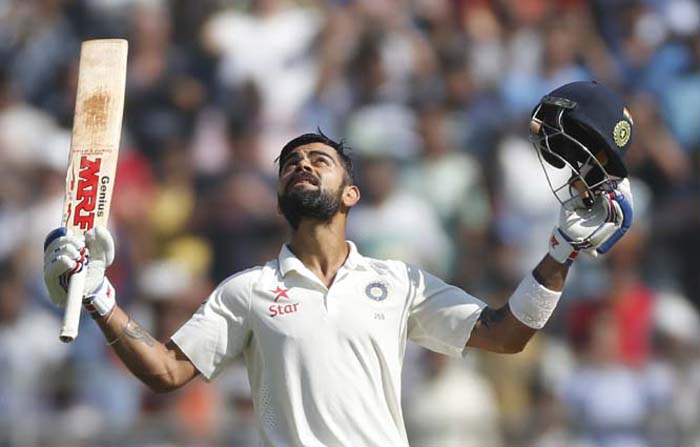 Indian captain Virat Kohli raises his bat and helmet after scoring double century on the fourth day of the fourth cricket Test match between India and England in Mumbai, India on Sunday.