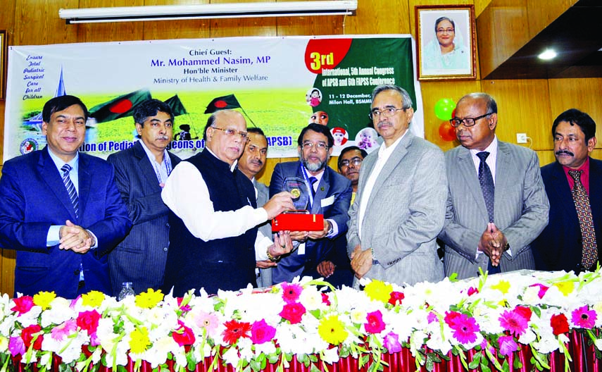 Health and Family Welfare Minister Mohammad Nasim handing over gold medal to the Chairman of Dhaka Community Hospital Trust Prof Dr Quazi Quamruzzaman as the best Paediatric Surgeon at a ceremony held at Bangabandhu Sheikh Mujib Medical University on Mond