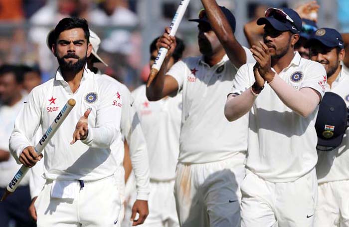India's captain Virat Kohli (left) carries a wicket as he celebrates with his team players after their win over England on the fifth day of the fourth cricket test match between India and England in Mumbai, India, Monday.