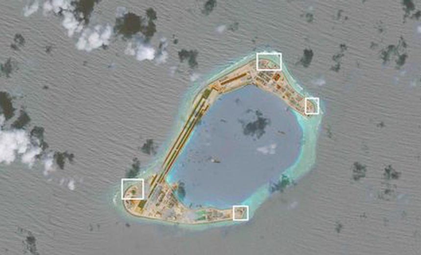 A satellite image shows what CSIS Asia Maritime Transparency Initiative says appears to be anti-aircraft guns and what are likely to be close-in weapons systems (CIWS) on the artificial island Subi Reef in the South China Sea.