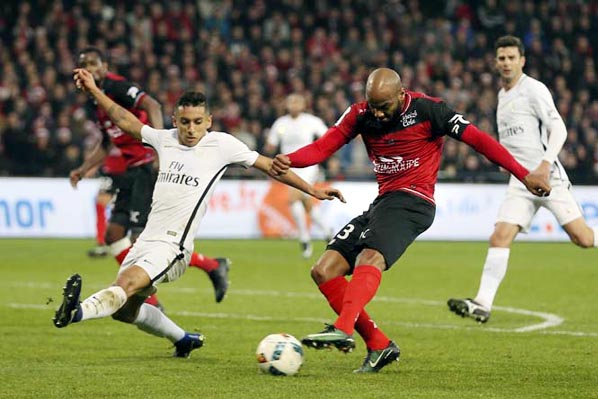 Jimmy Briand of Guingamp (right) attempts a shot at goal past PSG's Marquinhos during their League One soccer match, at the Roudourou stadium, in Guingamp, western France, Saturday.