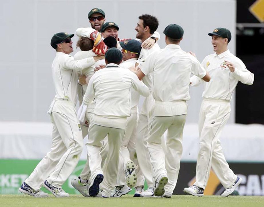 Australia celebrate victory after defeating Pakistan during play on the final day of the first cricket Test between Australia and Pakistan in Brisbane, Australia on Monday.