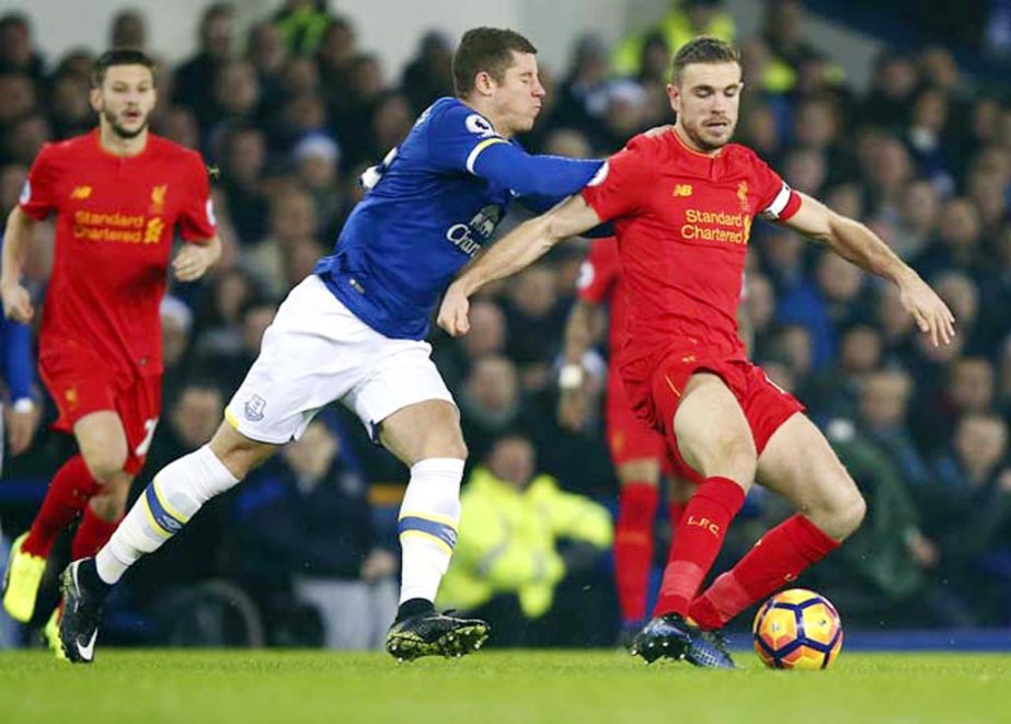 Liverpool's Jordan Henderson (right) vies for the ball with Everton's Ross Barkley during the English Premier League soccer match between Everton and Liverpool at Goodison Park stadium in Liverpool, England on Monday.