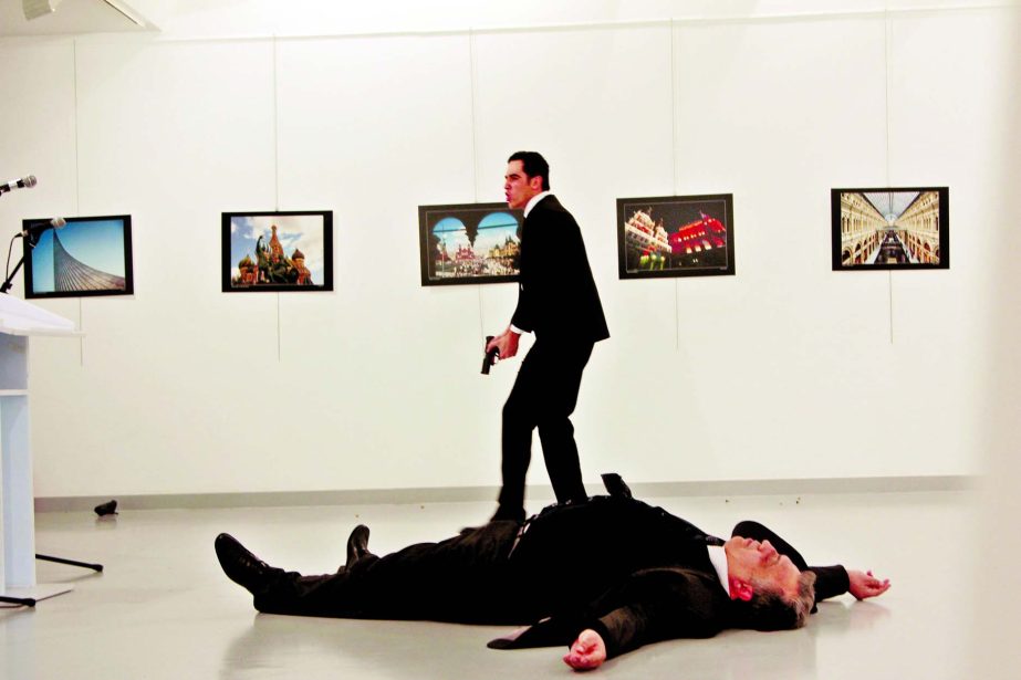A man, reported by The Associated Press to be the gunman, after the shooting of the Russian Ambassador, on the floor, on Monday at a gallery in Ankara, the capital of Turkey.