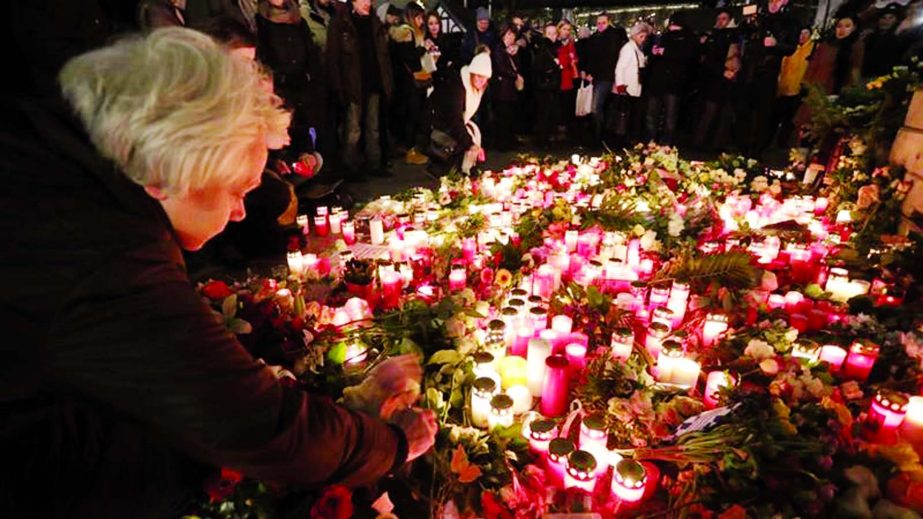 Members of the public light candles at the site of the attack on a Christmas market in Berlin. At least 12 people were killed when a truck drove into a Christmas market.