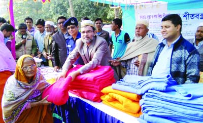 NAOGAON: Upazila Chairman Alhaj Shamsul Alam Chowdhury distributing winter clothes among the distressed people on behalf of Manobater Sabay Amra, an NGO at Sapahar Upazila recently.