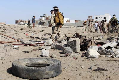 Soldiers gather the site of a suicide bomb at a base in the southern city of Aden, Yemen