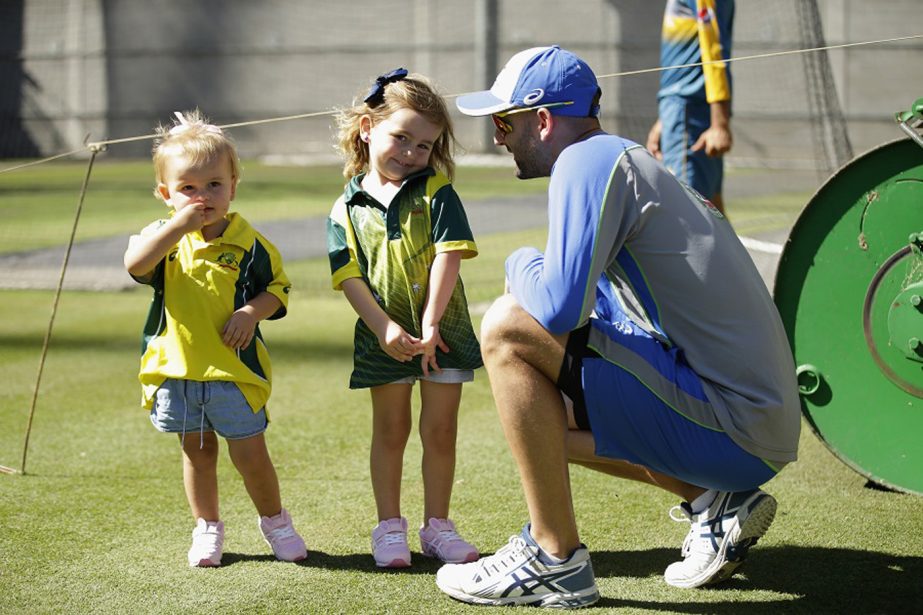 Nathan Lyon takes a break with his children Milla and Harper during an Australian nets session in Melbourne, Australia on Sunday.