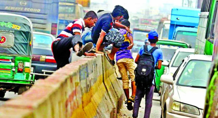 Hundreds of pedestrians crossing the main thoroughfare in city ignoring the footover bridges and traffic signals, risking their lives everyday. This photo was taken from Dhaka-Chittagong Highway near the end of Hanif flyover at Jatrabari on Tuesday.