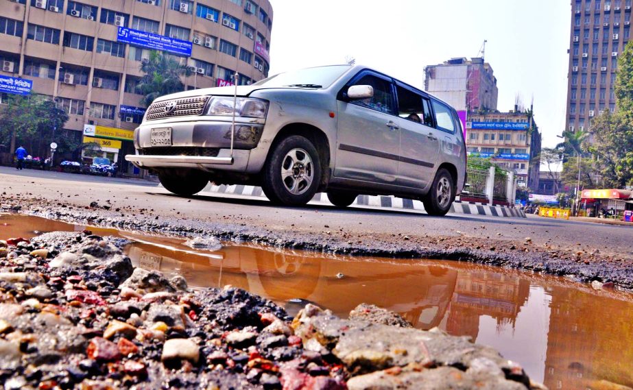A badly damaged road in the city's business hub Motijheel Commercial Area has been hampering smooth movement of vehicles for a long time but the authority concerned seem to turn a blind eye on it. This photo was taken on Friday.