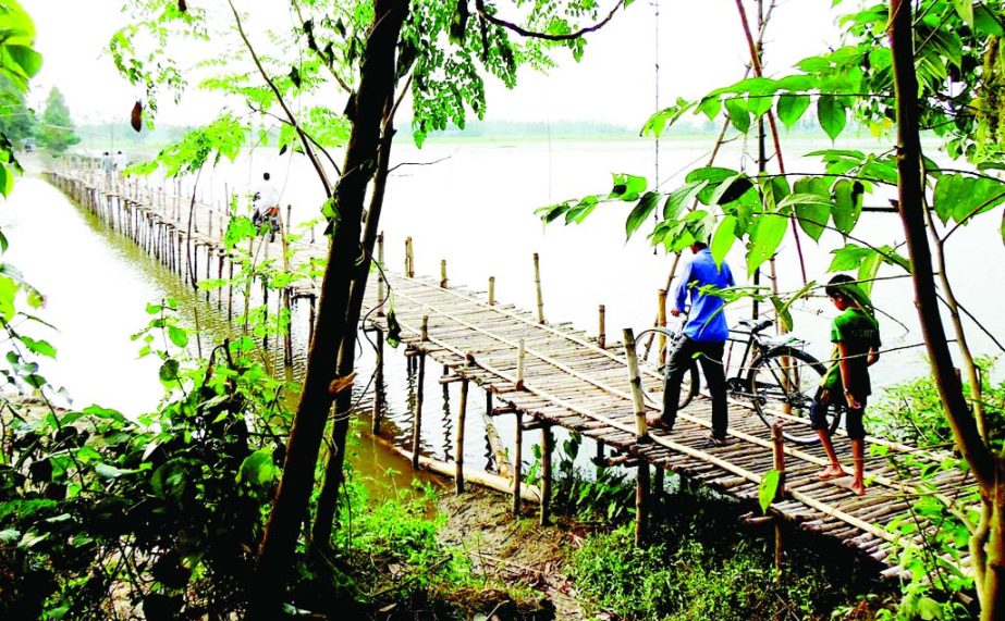 JAMALPUR: An iron bridge is urgently needed at Hatidanga Union on Chakar Beel as 20 thousand people of eight villages are using the bamboo bridge at the risk. This picture was taken on Tuesday.