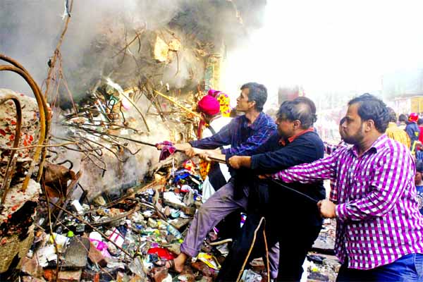 Shop owners and traders of fire-hit Gulshan DCC market are seen on Wednesday trying to recover some goods that are not yet totally charred.