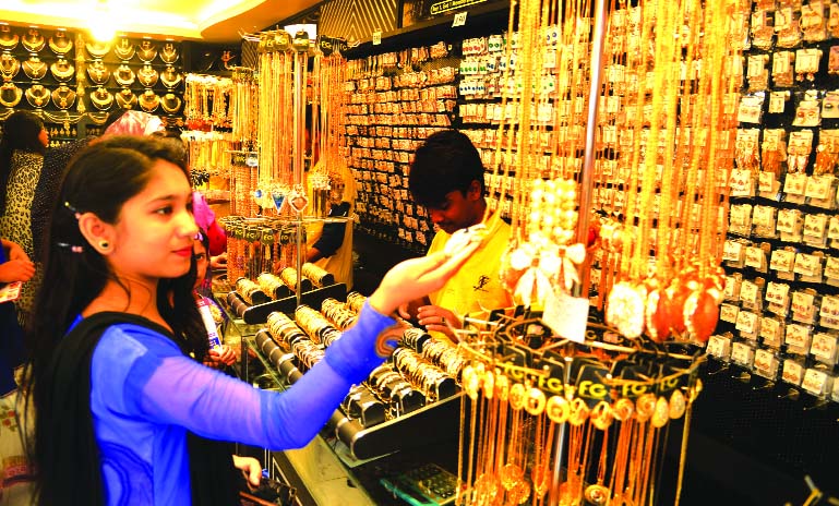 Dhaka International Trade Fair is yet not booming its business. A girl is making her choice ornaments at a stall. This photo was taken on Thursday.
